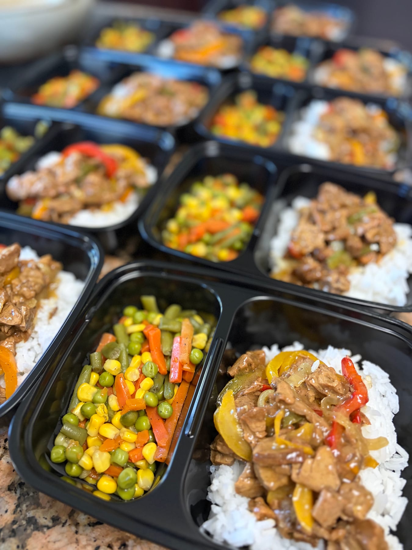 Pepper steak, rice, and mixed vegetables in meal-prep trays
